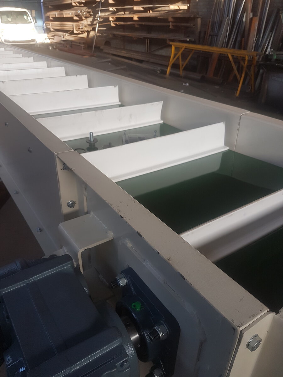Steep incline belt conveyor in a processing plant