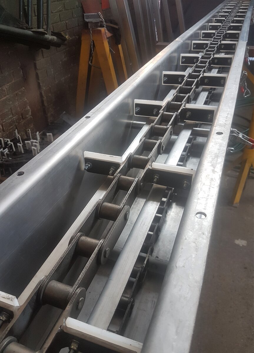 Drag chain conveyor end view by Facet Engineering