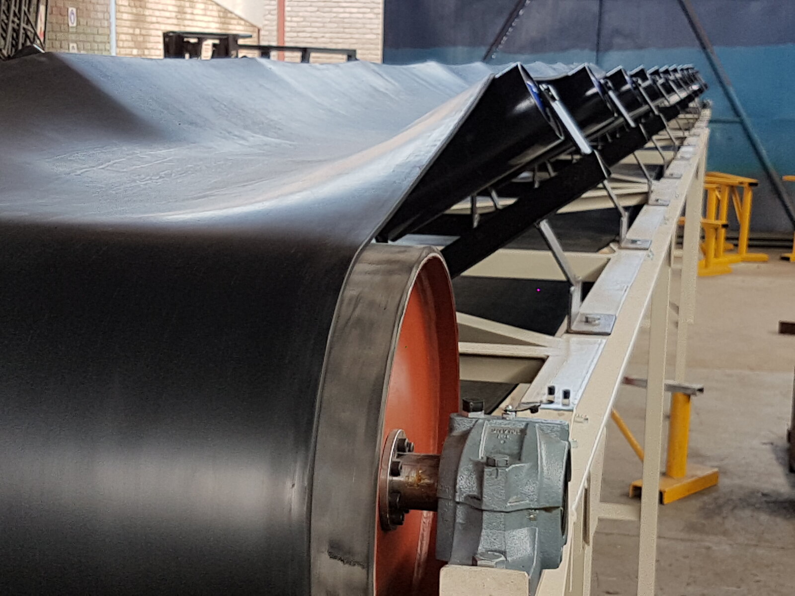 Troughed belt conveyor drive end