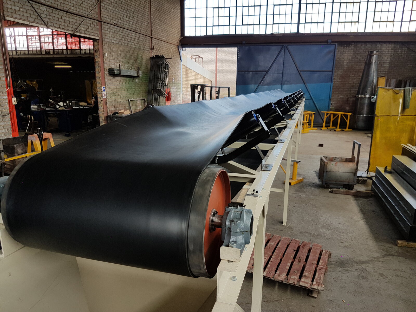 Troughed belt conveyor in a grain handling facility